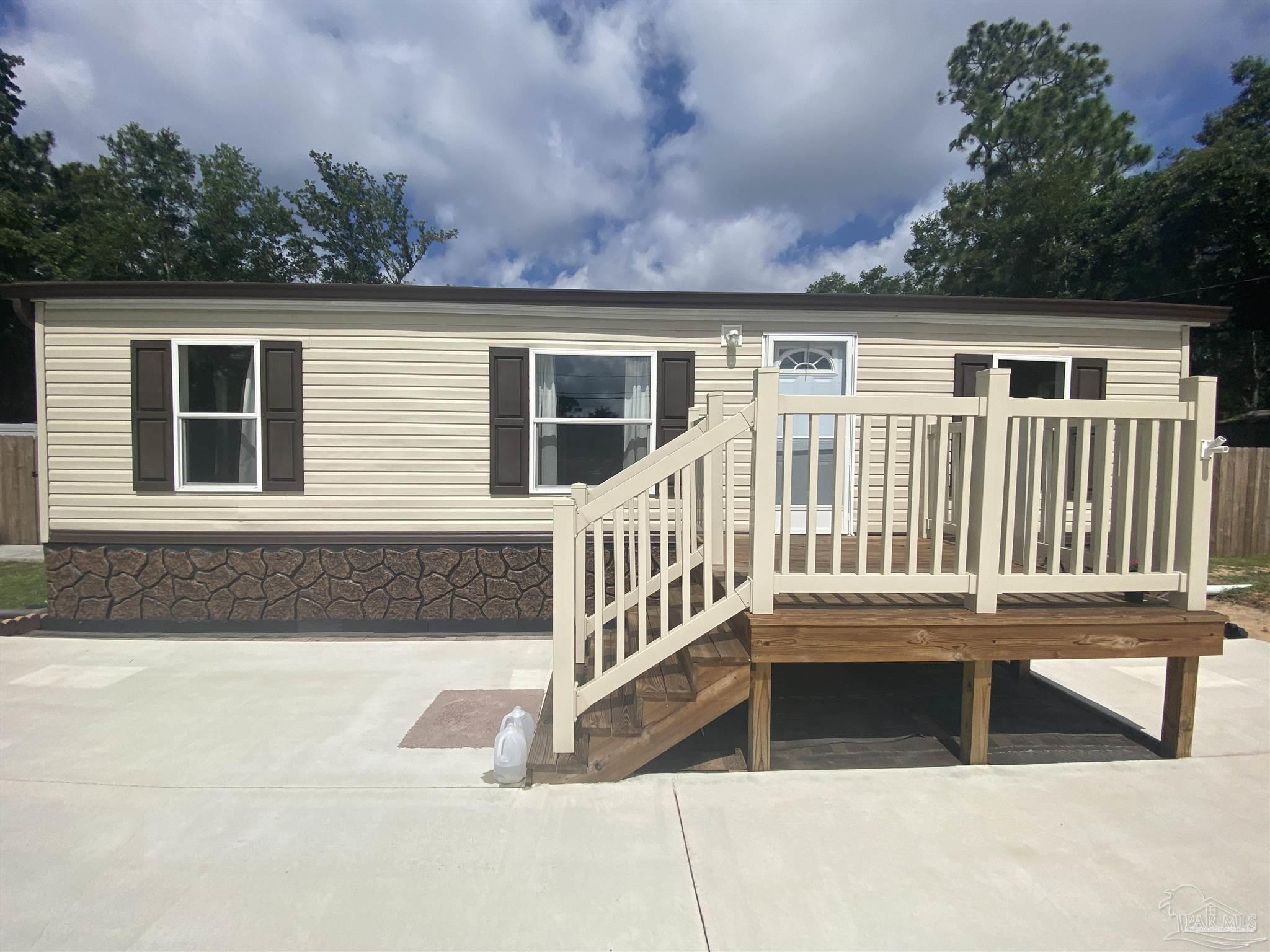 a view of a house with a deck and a large tree