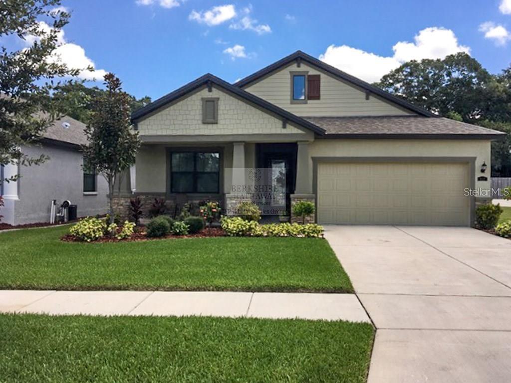 a front view of a house with a garden and plants