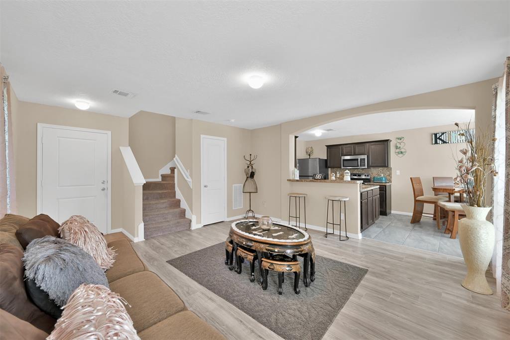 a living room with furniture dining table and kitchen view