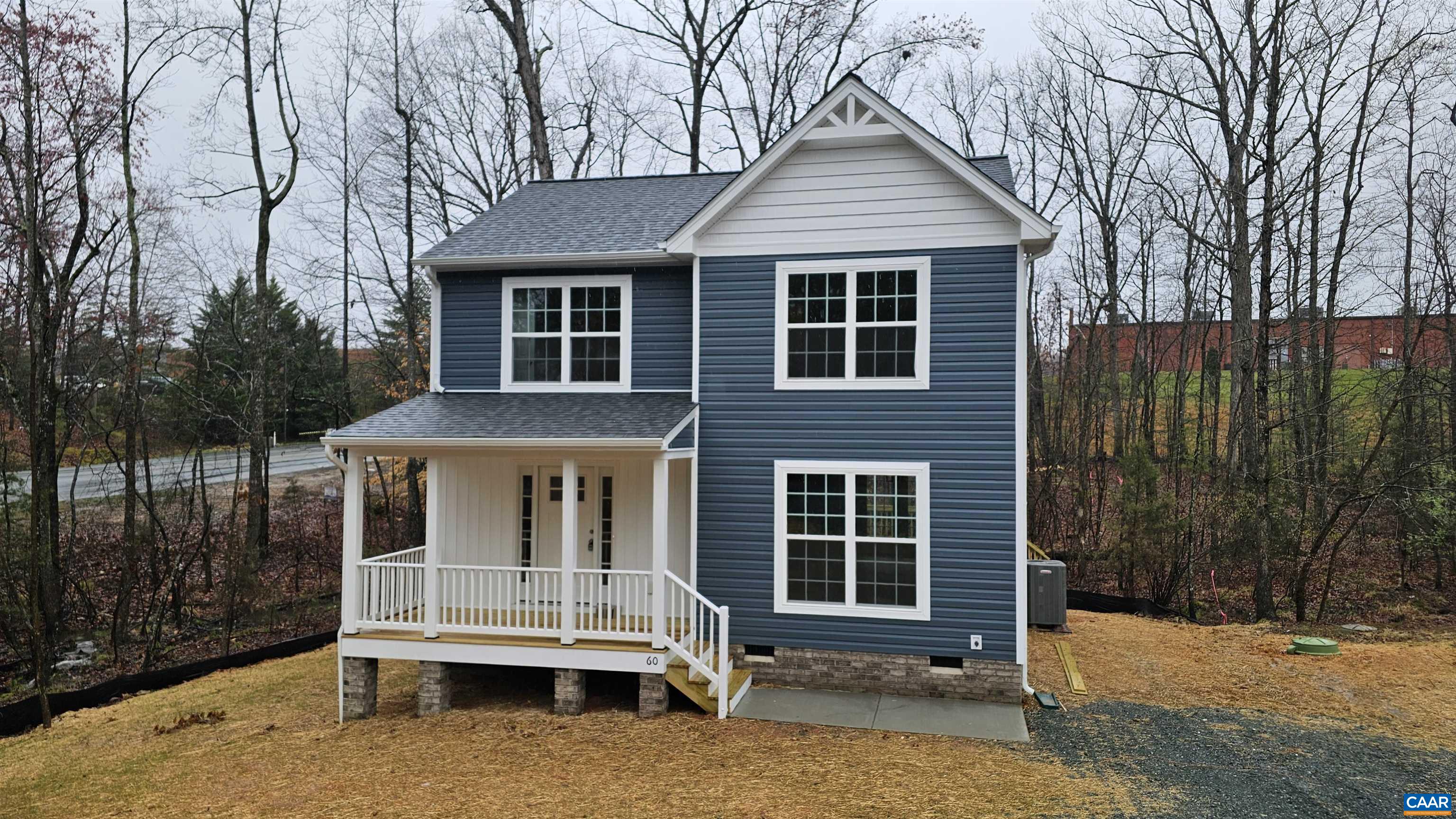 a view of house with a yard in the background