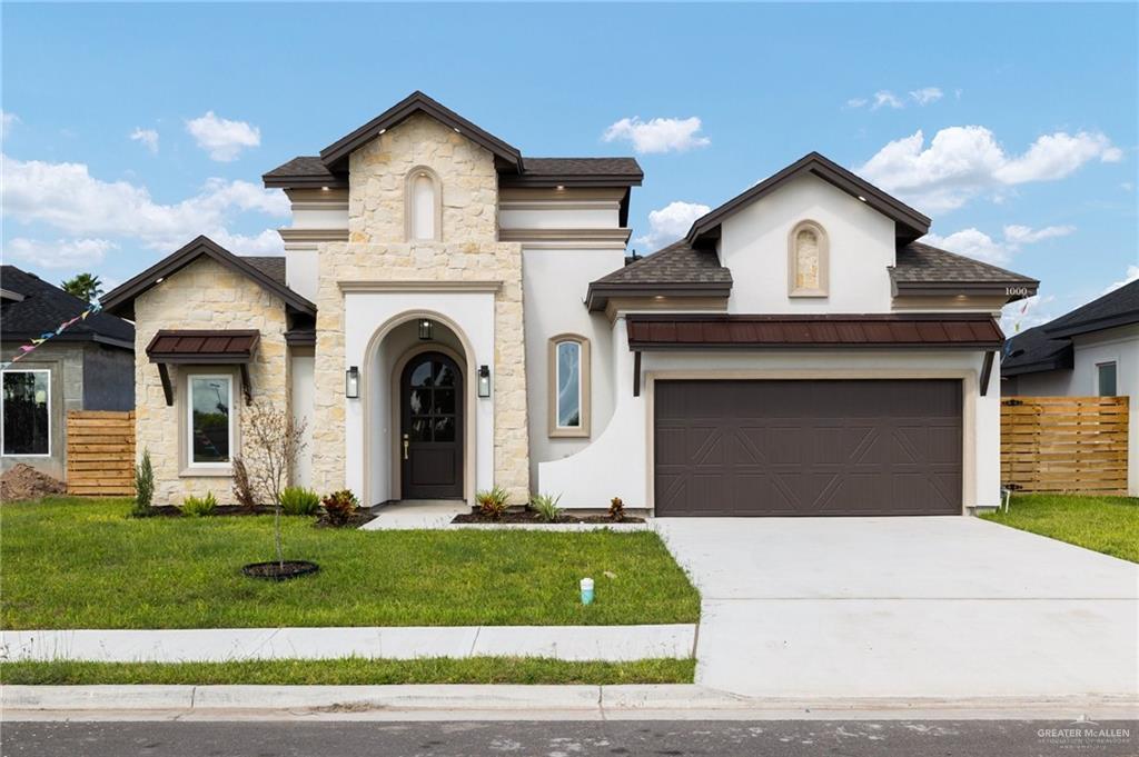 View of front of house featuring a garage and a front lawn