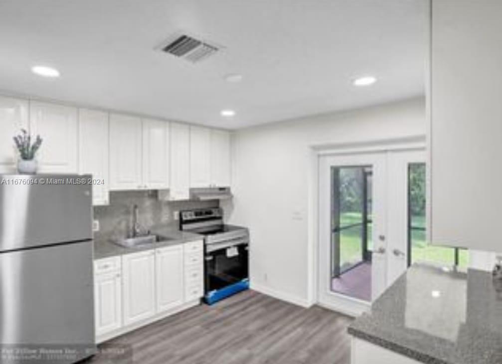 a kitchen with a refrigerator and a sink