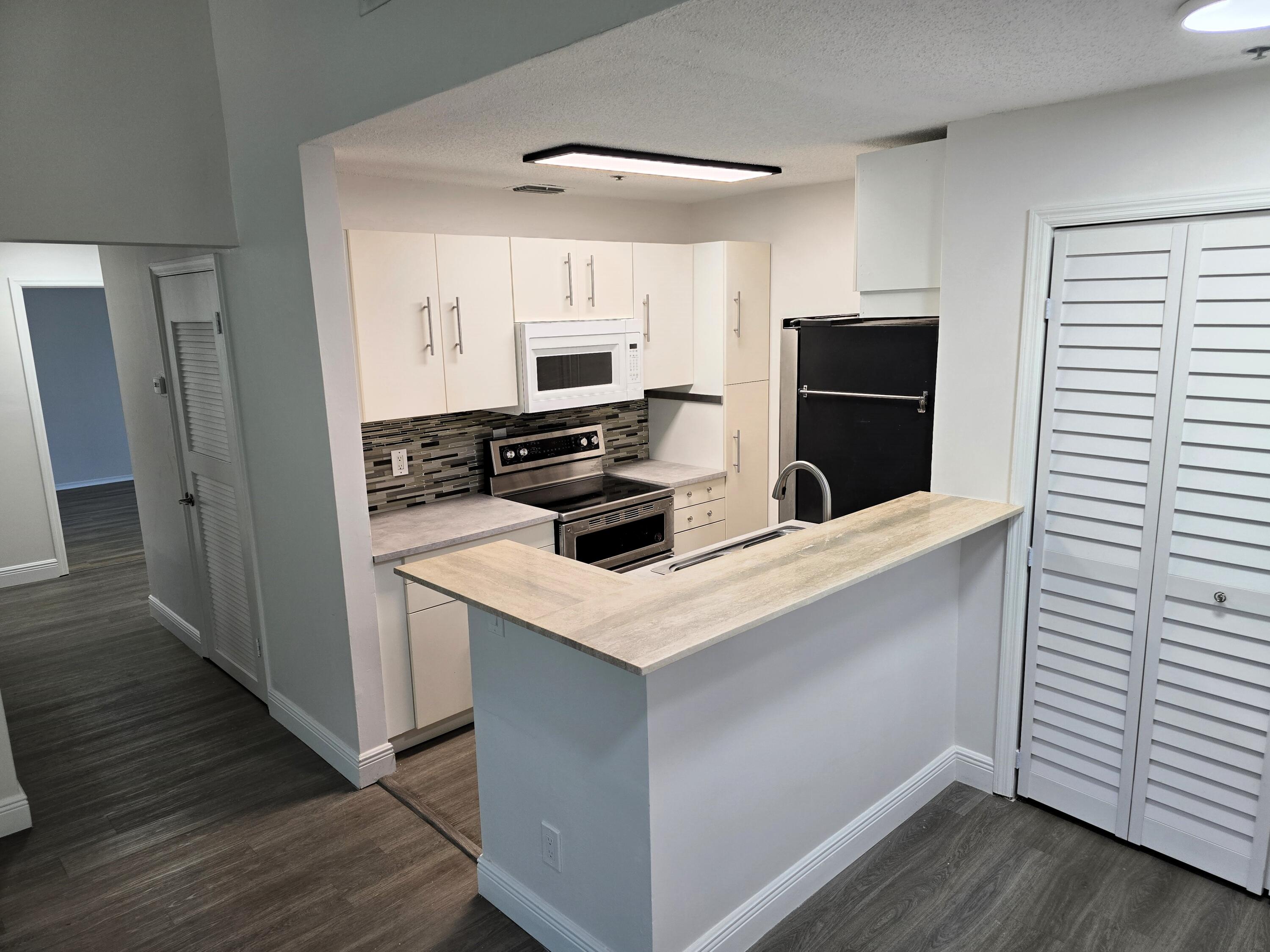 a kitchen with stainless steel appliances a refrigerator stove and microwave