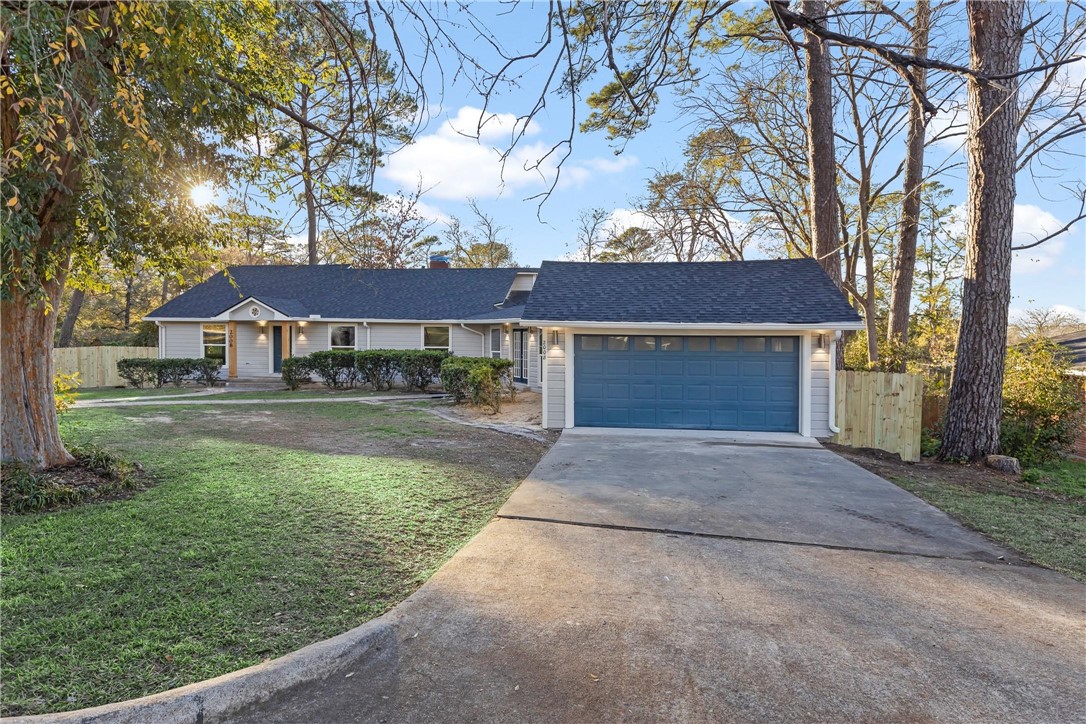 Ranch-style house featuring a front lawn and a gar