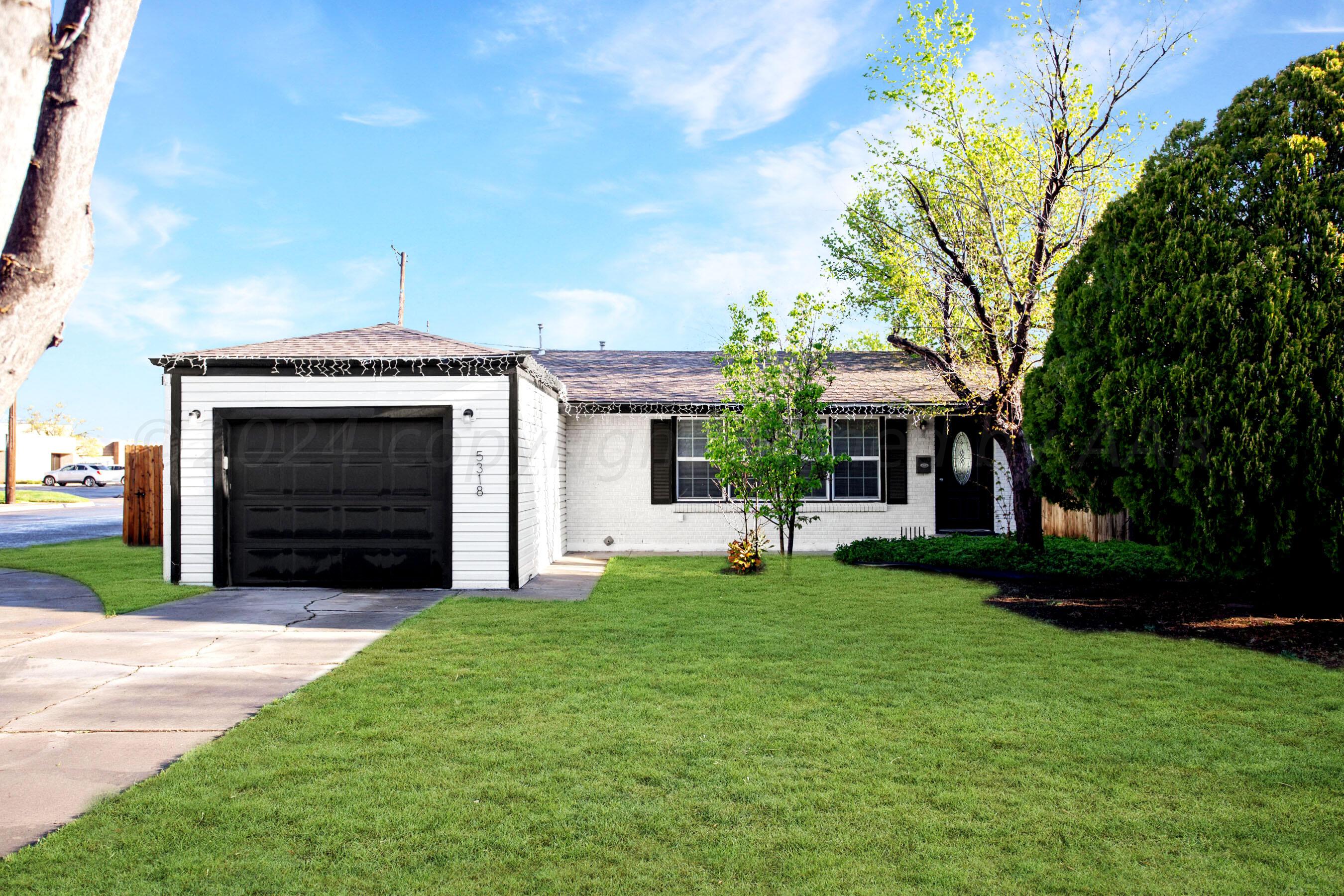 a view of a house with a yard and sitting area