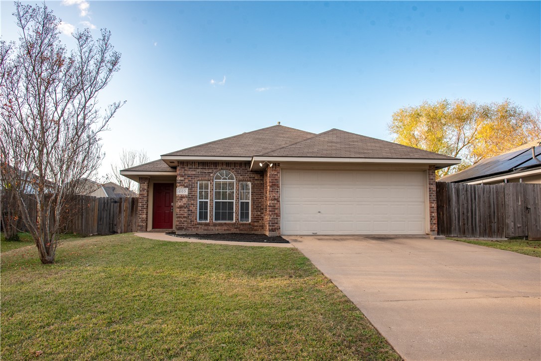 Single story home featuring a front lawn and a gar