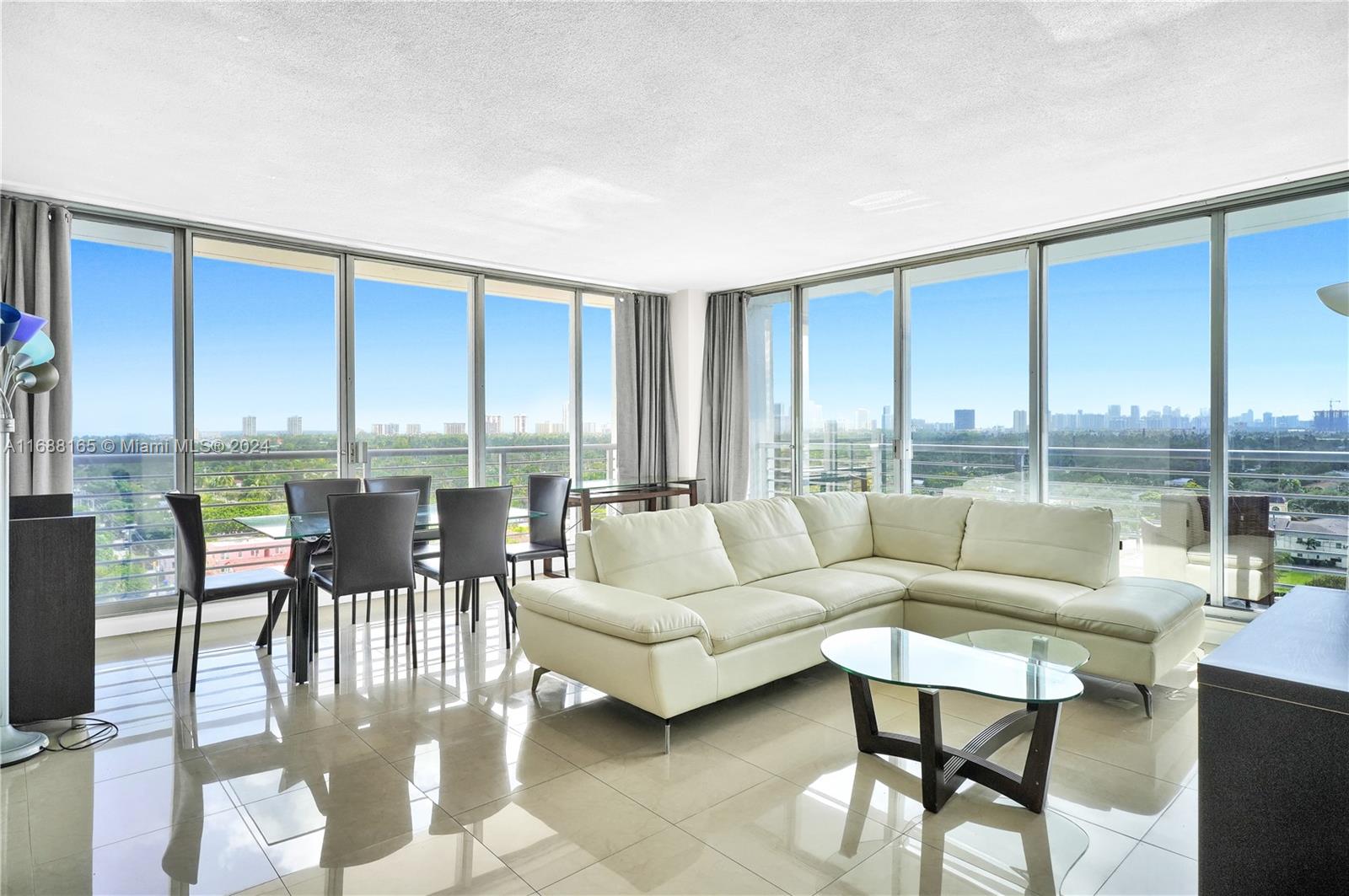 a living room with furniture wooden floor and a floor to ceiling window