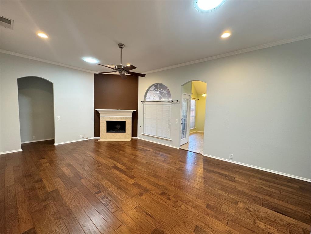 an empty room with a fireplace wooden floor and windows