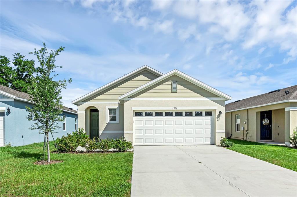 a front view of a house with a yard and garage