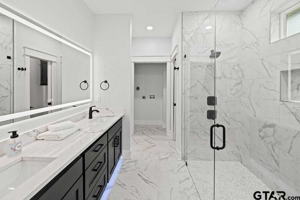 a bathroom with a granite countertop sink a shower and a mirror