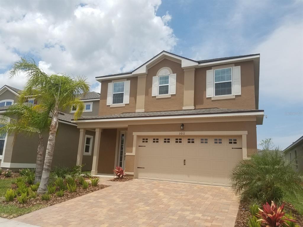 a view of a house with a garage and outdoor seating