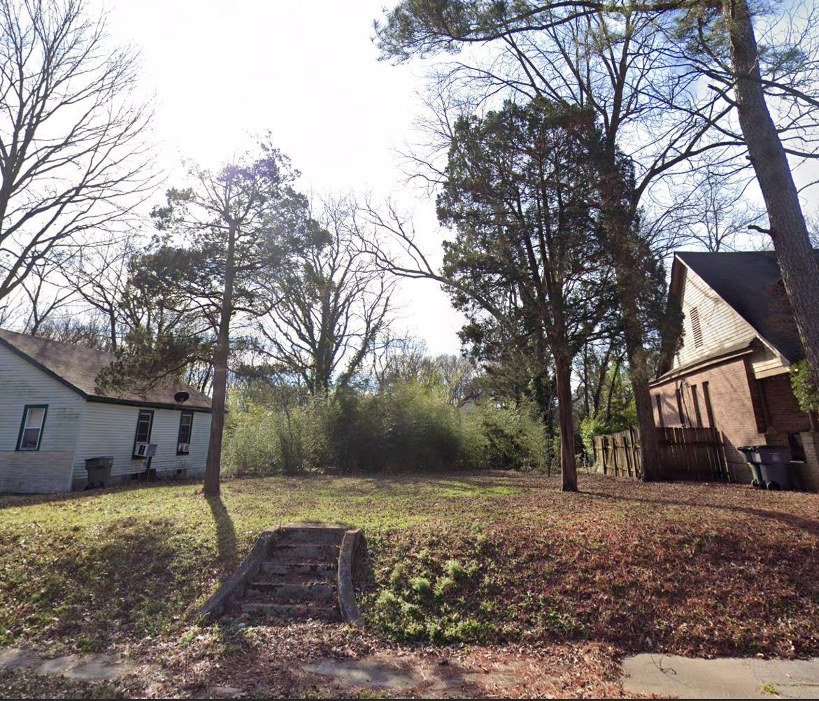 a view of a house with backyard and tree