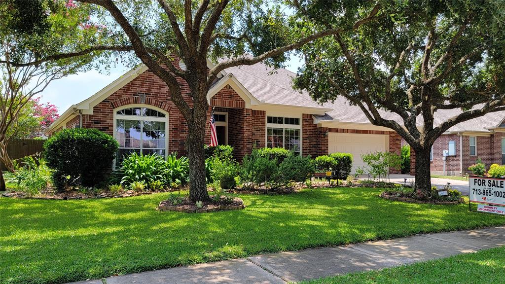 Charming home with exquisite landscaping, nestled beneath majestic oaks.