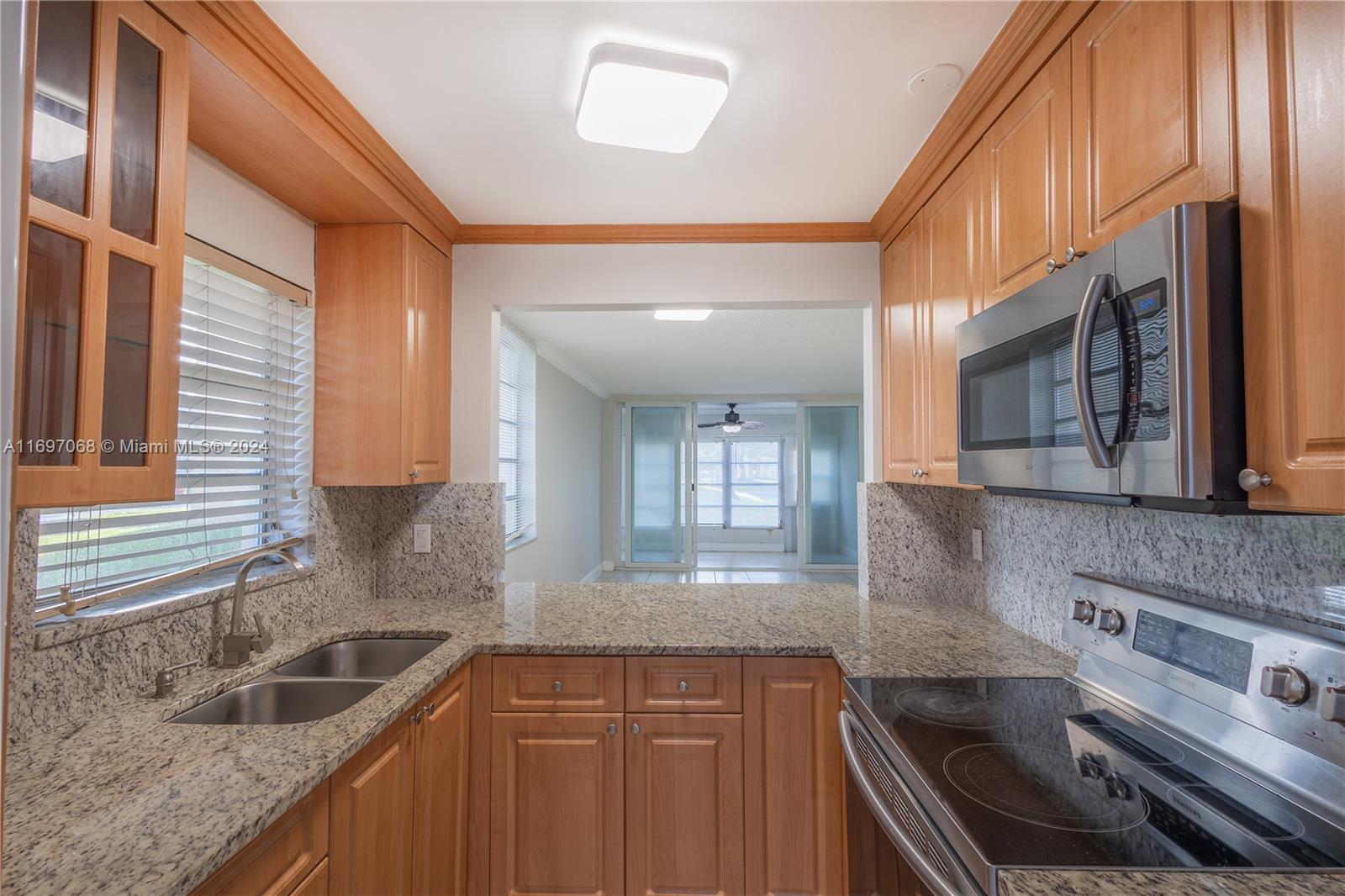 a kitchen with granite countertop a sink stove and cabinets