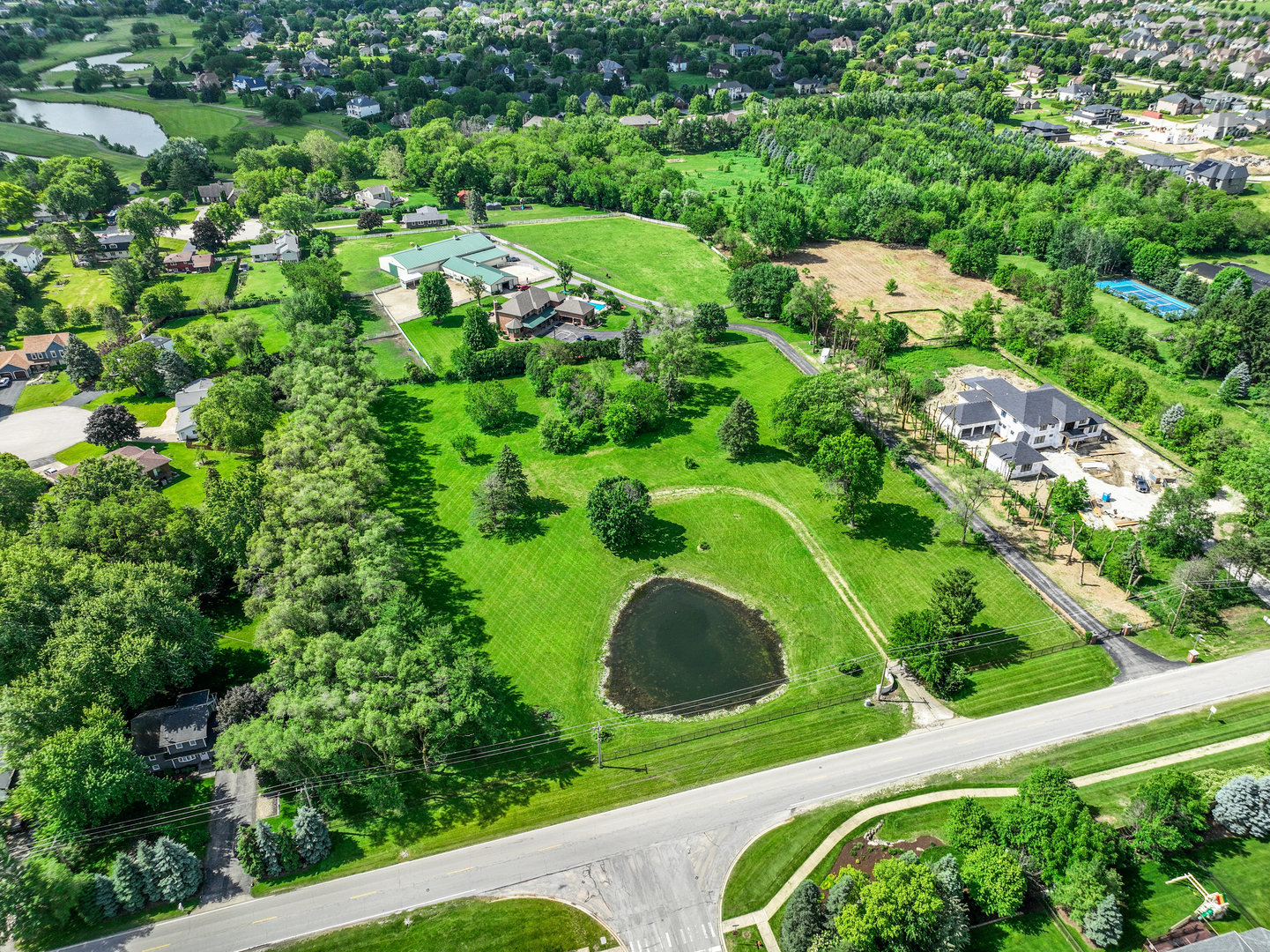 an aerial view of residential houses with outdoor space and trees