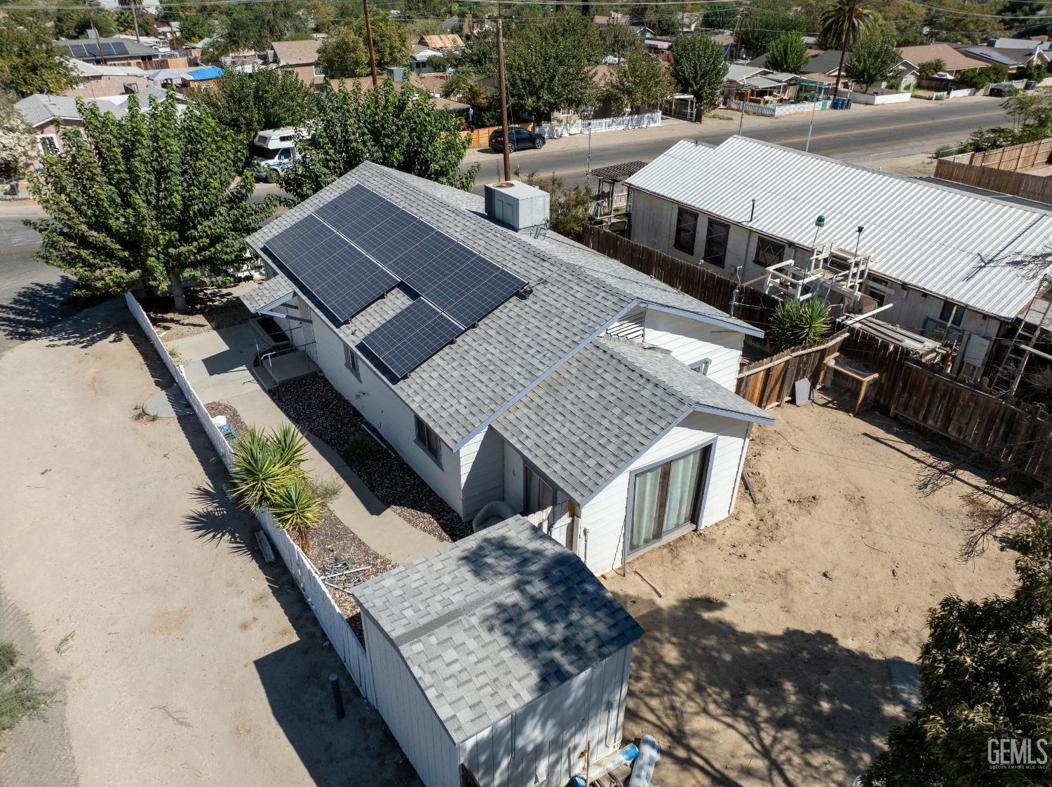 an aerial view of a house with swimming pool and large trees