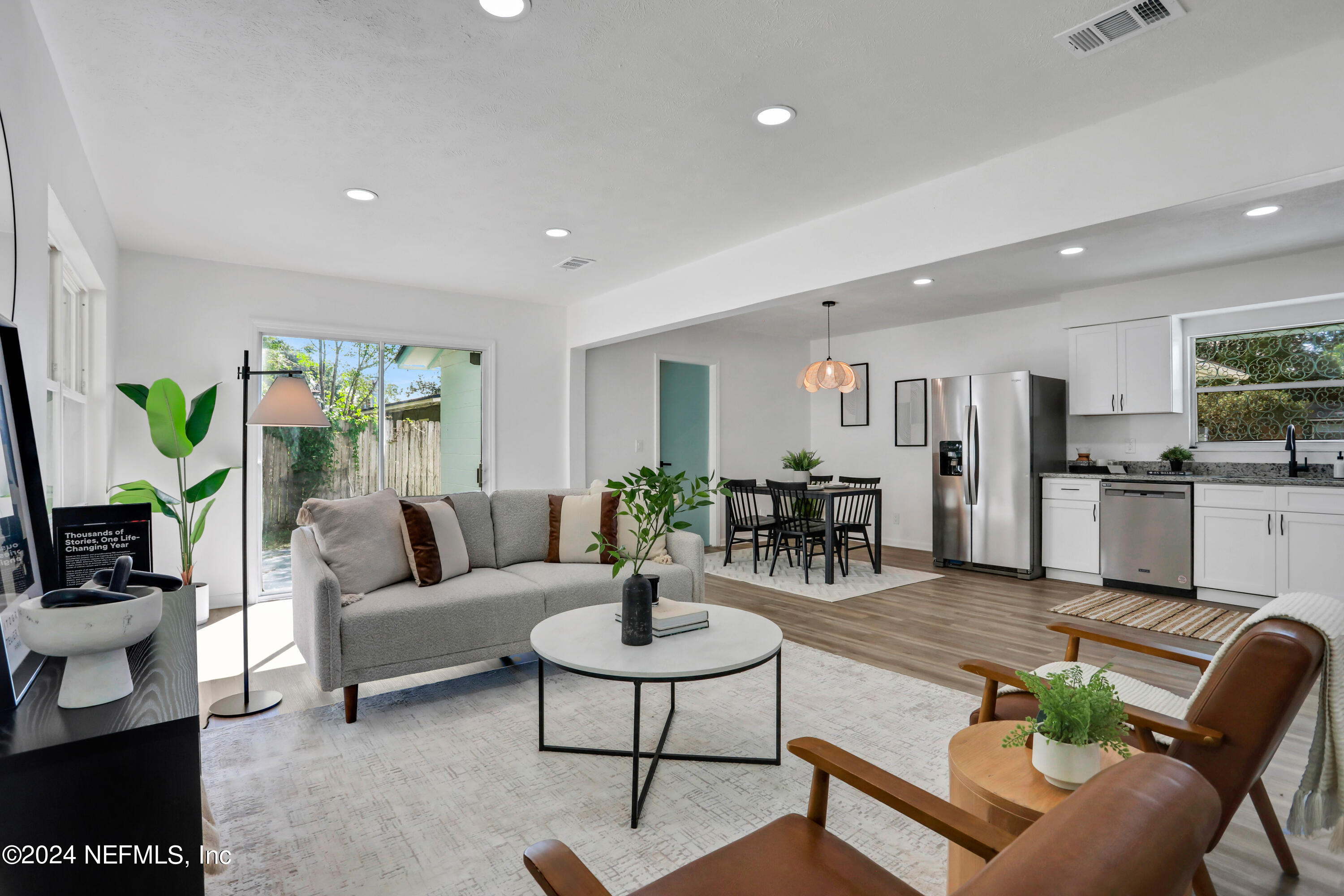 a living room with furniture white walls and a view of kitchen