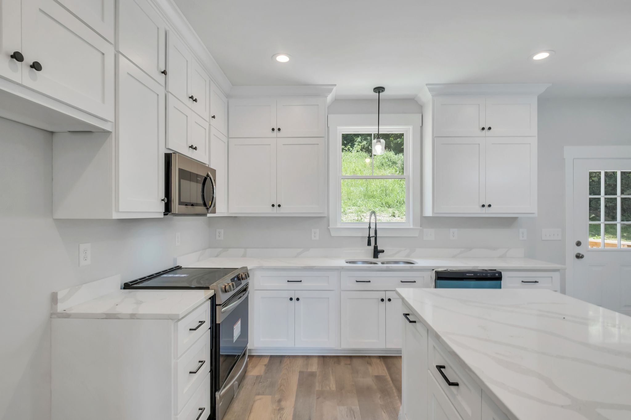 a kitchen with cabinets appliances a sink and a window