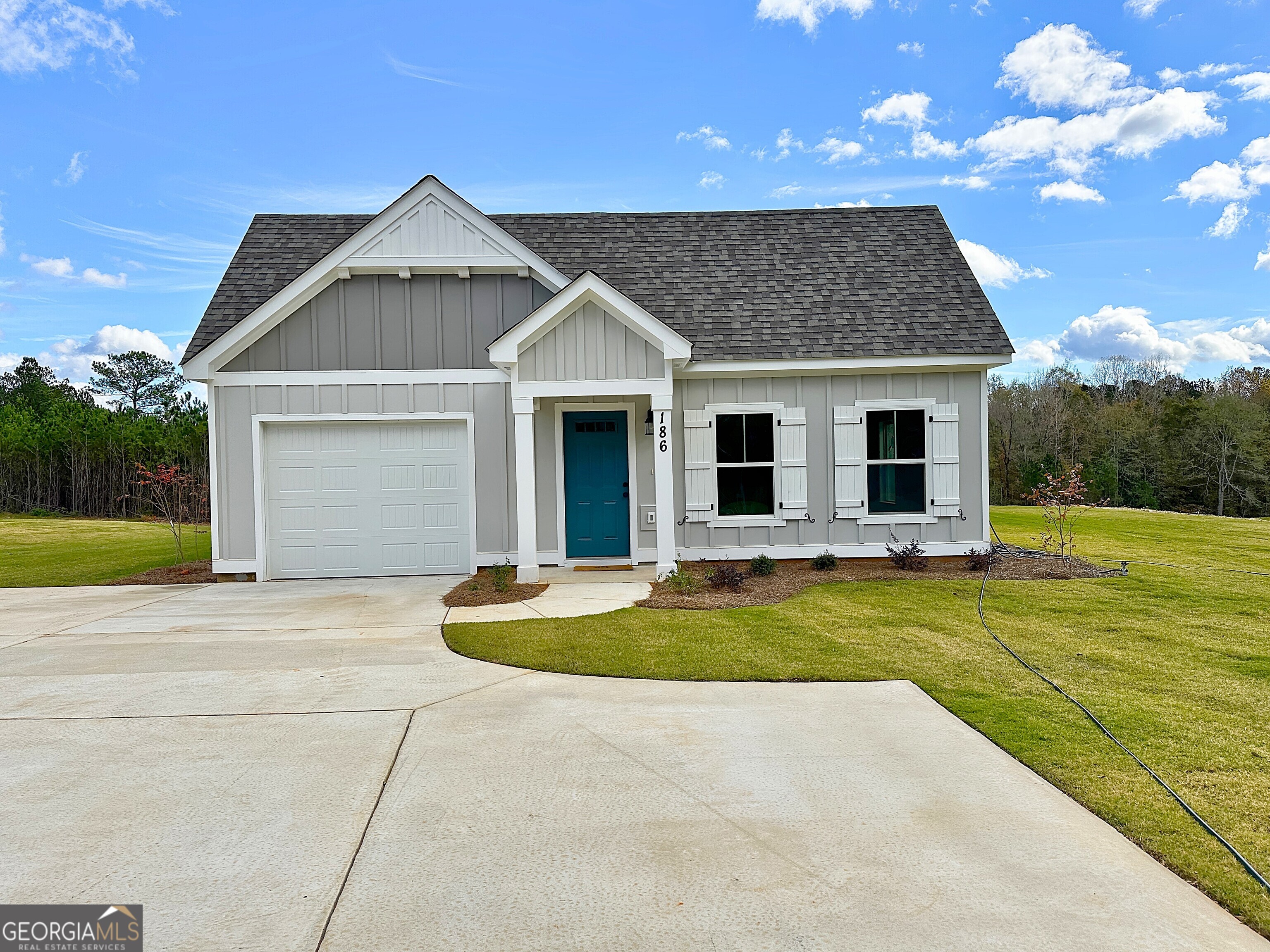 a front view of house with yard and trees in the background