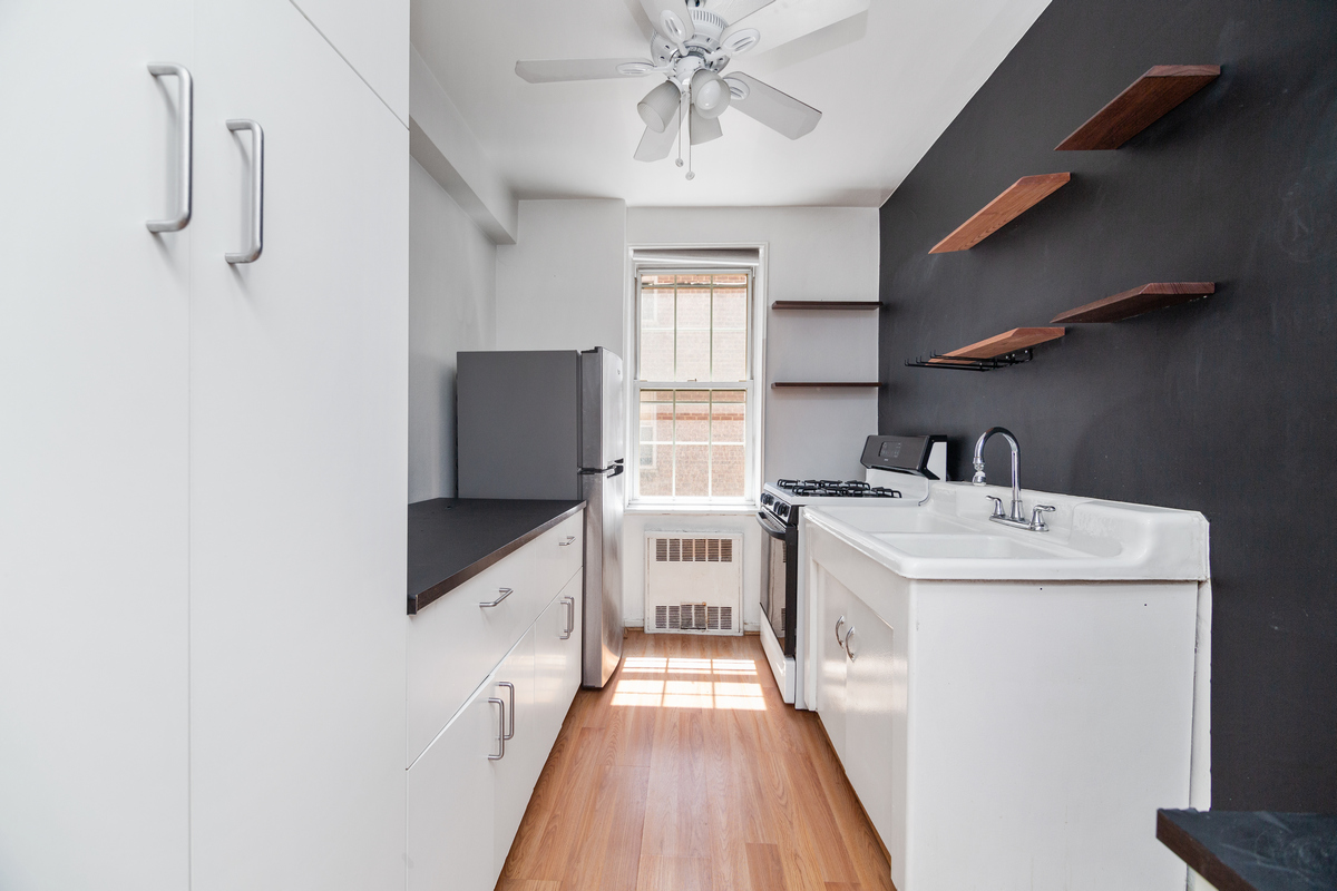 a kitchen with a sink a counter top space stainless steel appliances and cabinets