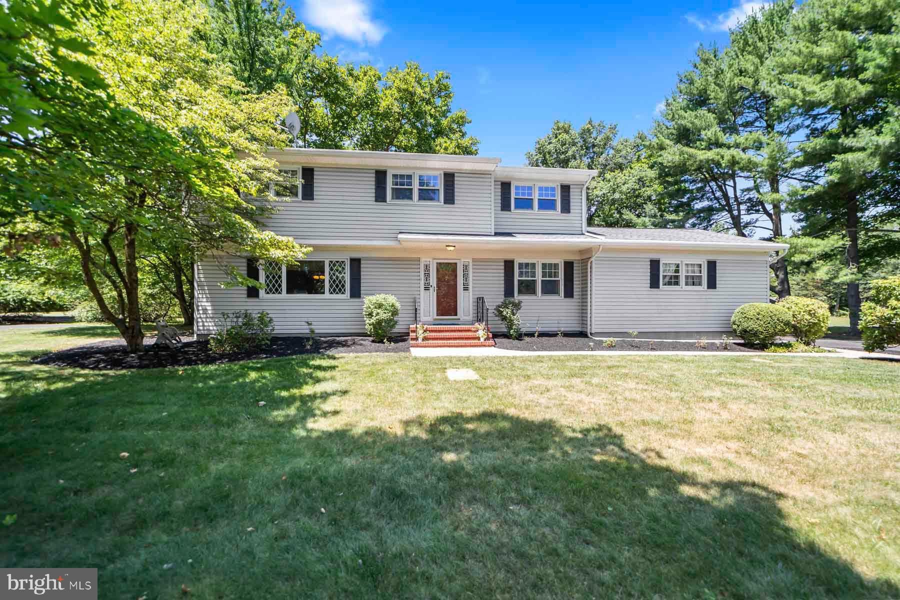 a view of a house with a big yard and large trees