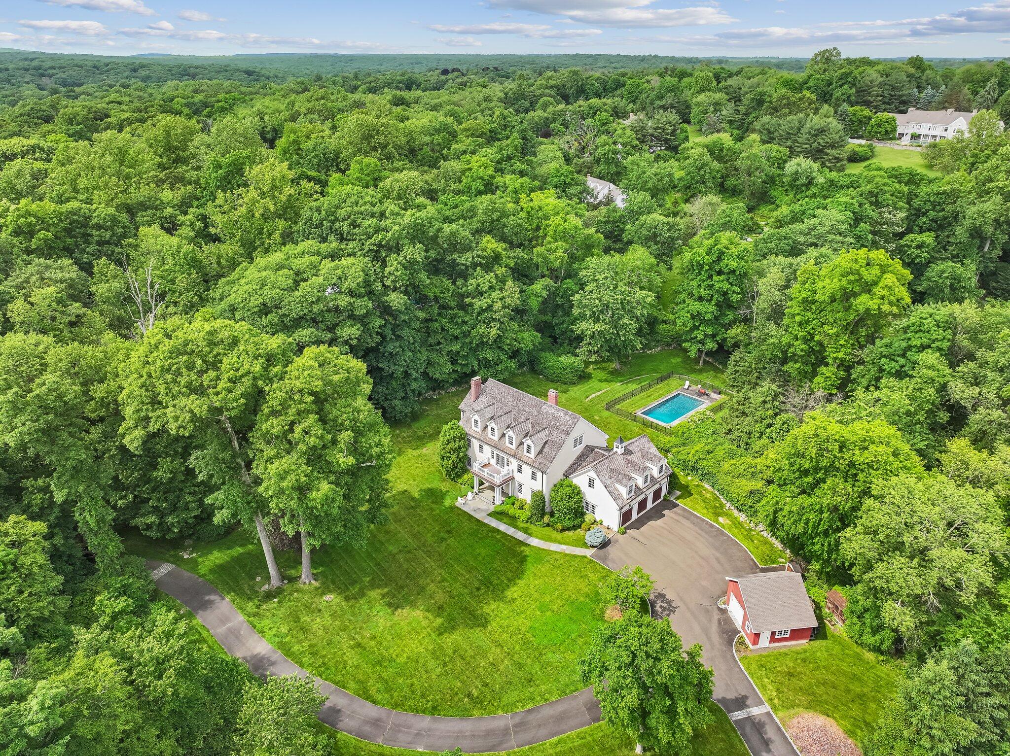 an aerial view of a house with a yard and trees