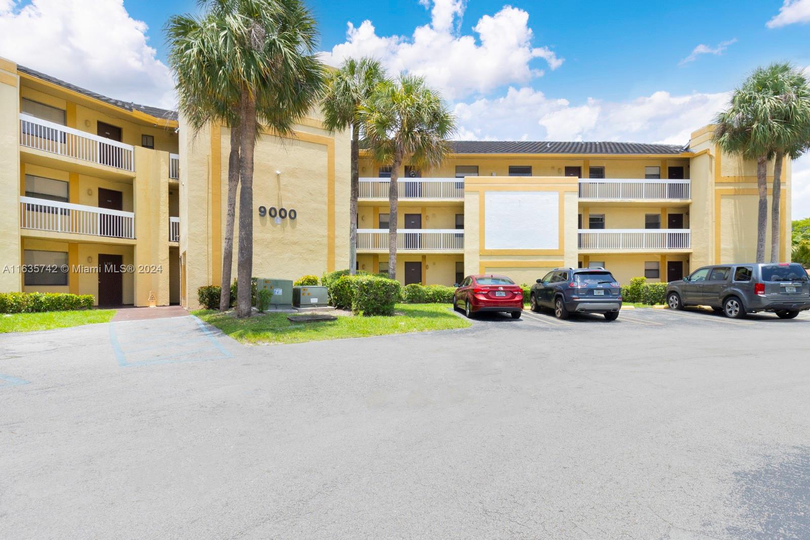 a front view of a building with cars parked