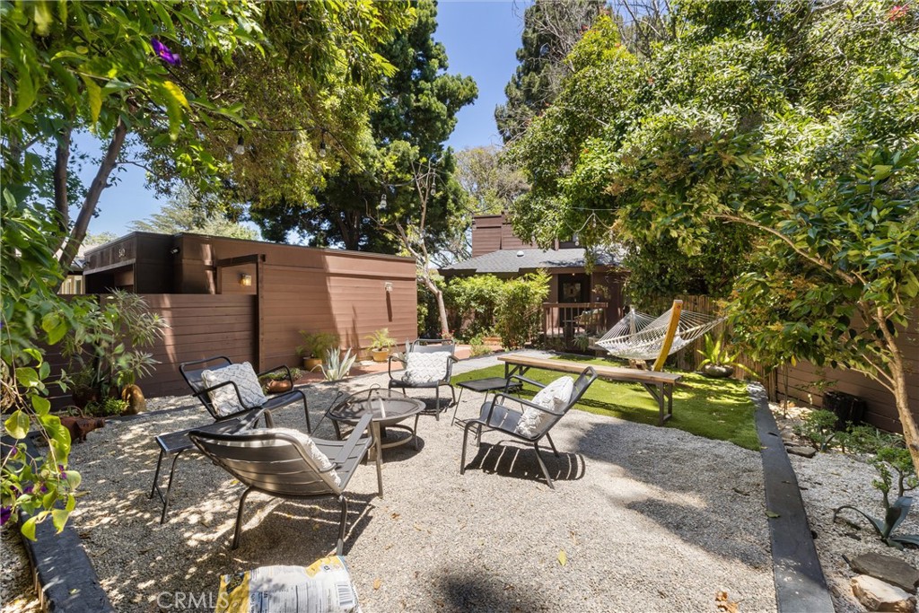 a view of backyard of house with yard table and chairs