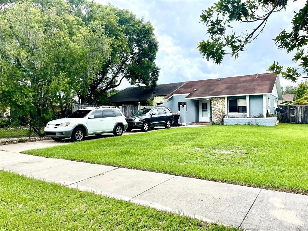 a front view of a house with a garden and trees