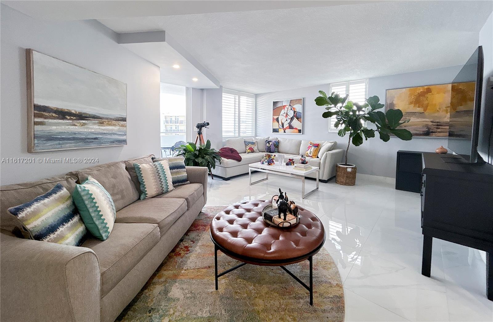 a living room with furniture potted plant and a large window