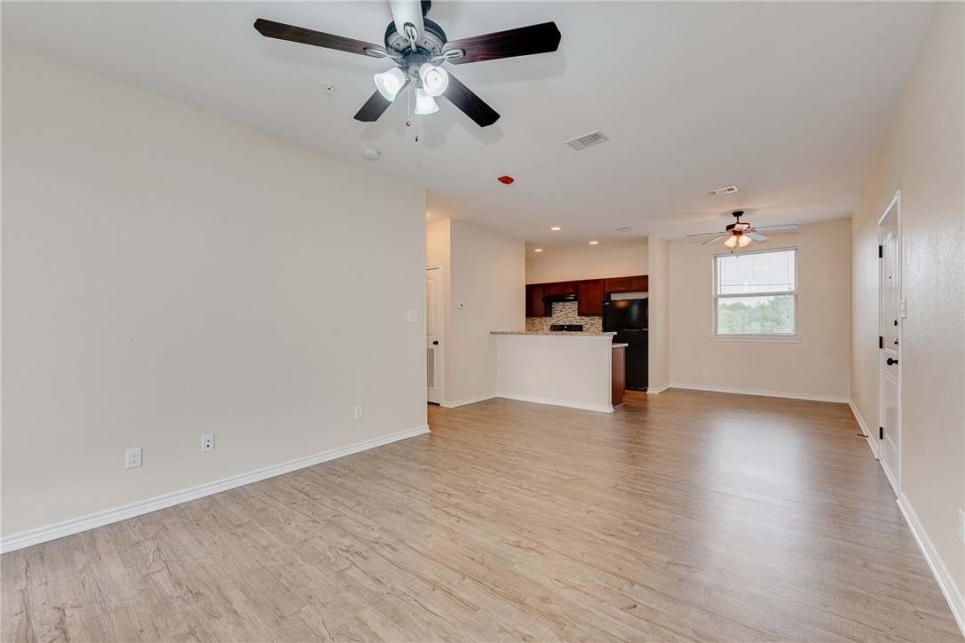 Unfurnished living room with ceiling fan and light