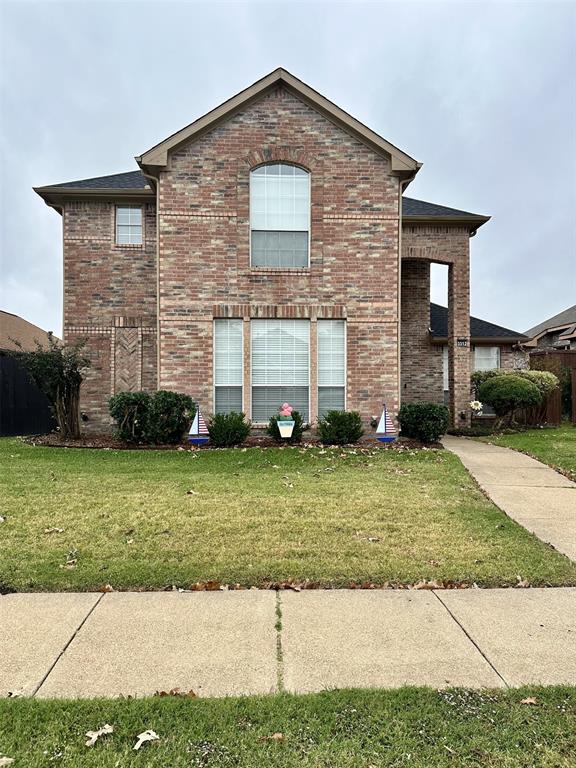 a view of a brick house with a yard