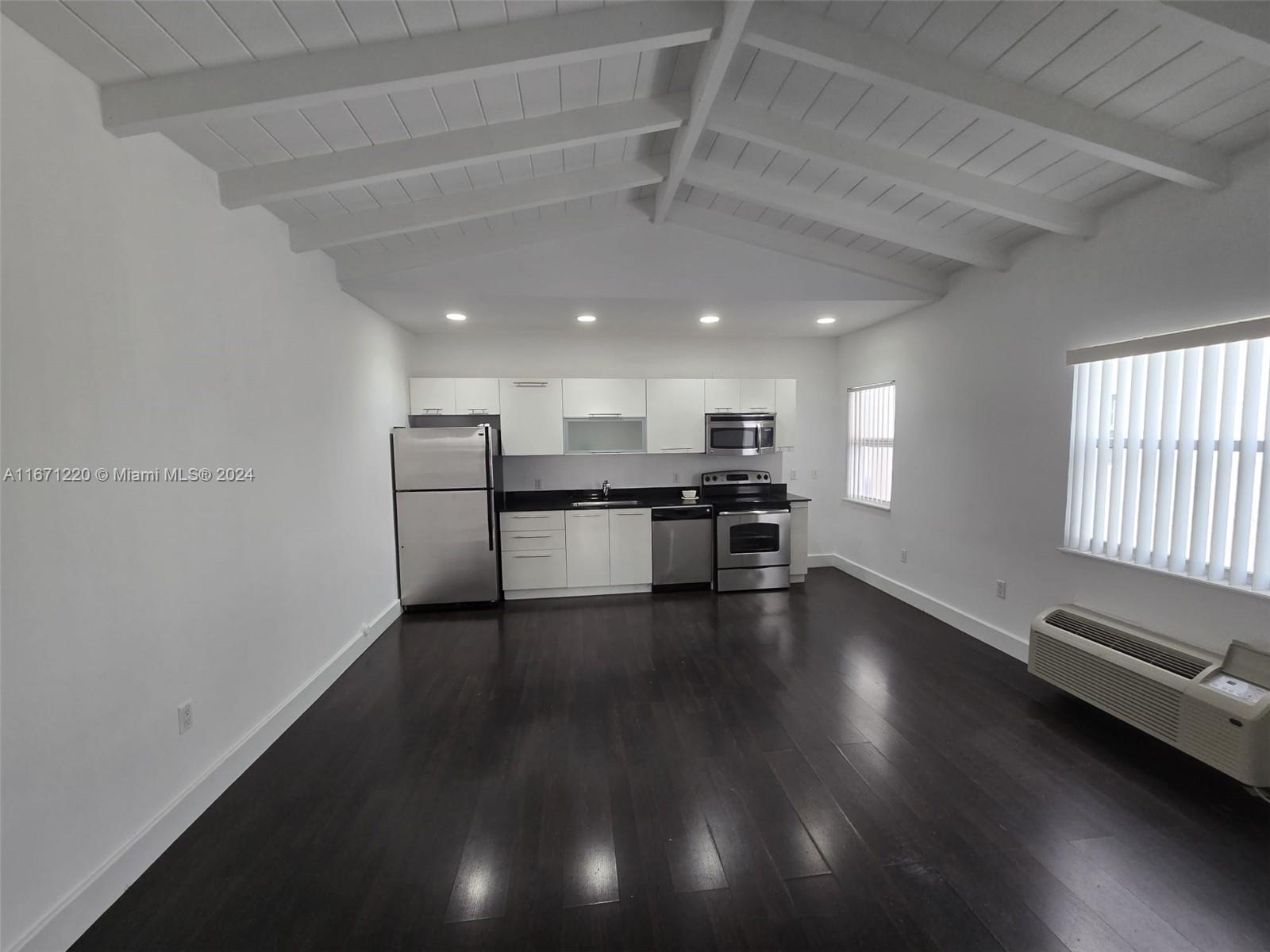 a view of kitchen with stove and cabinets