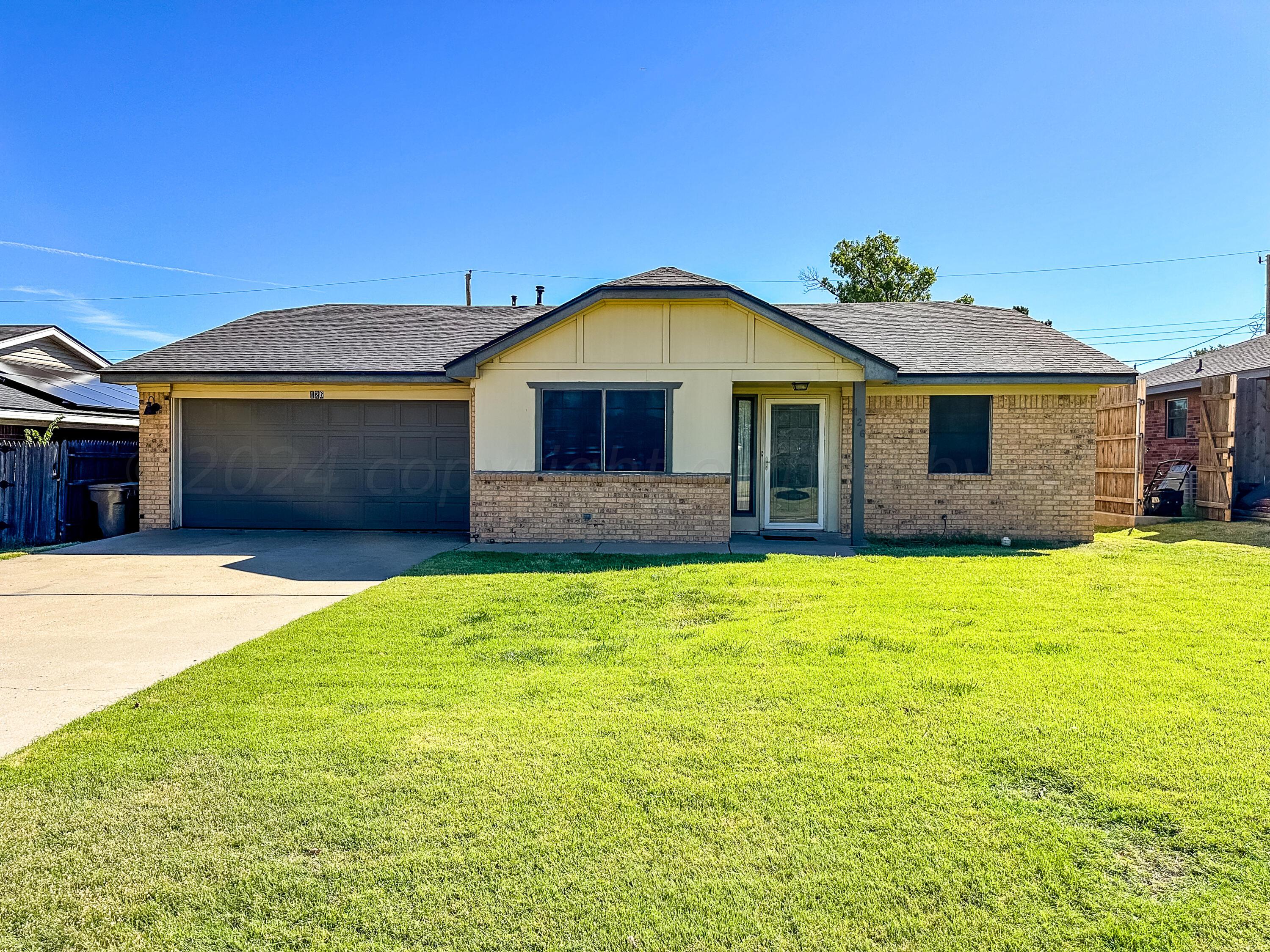 a front view of a house with a garden and yard