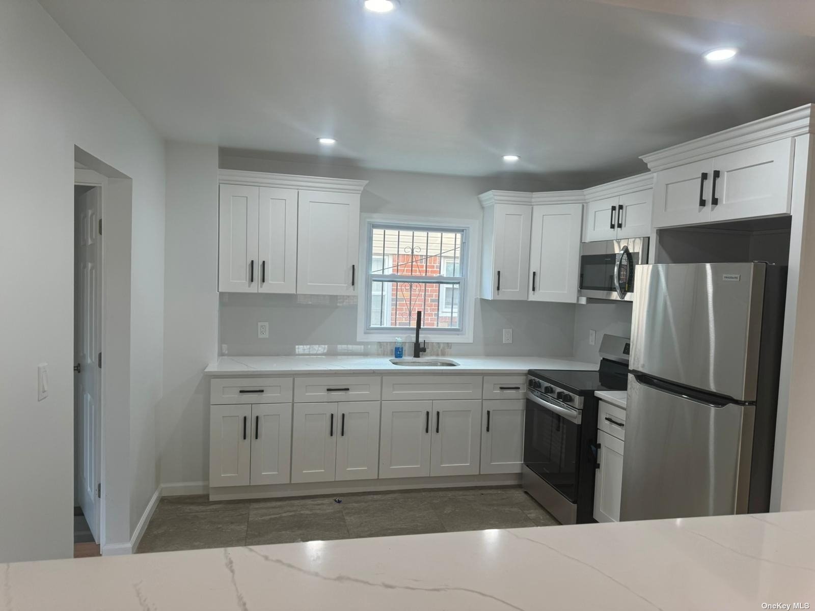 a kitchen with a sink window and refrigerator