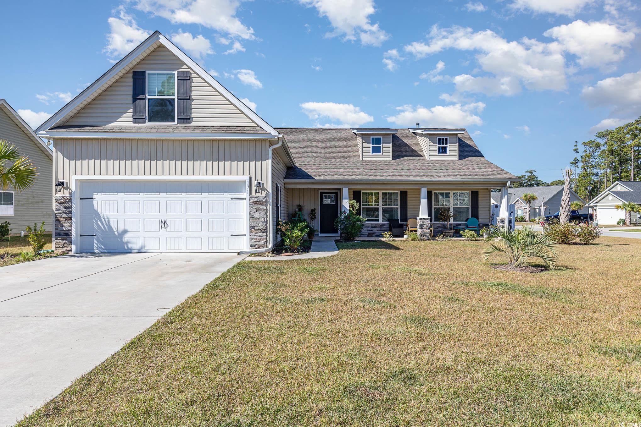 View of front of house with a front yard and cover