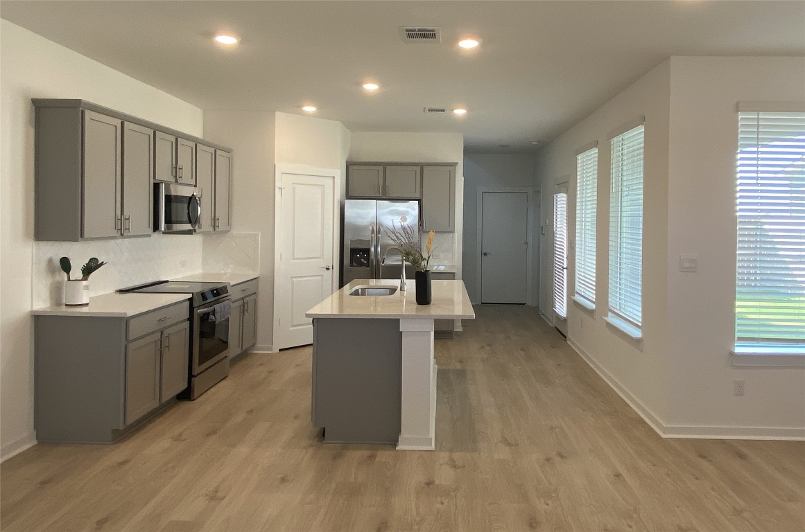 a view of kitchen with sink microwave and refrigerator