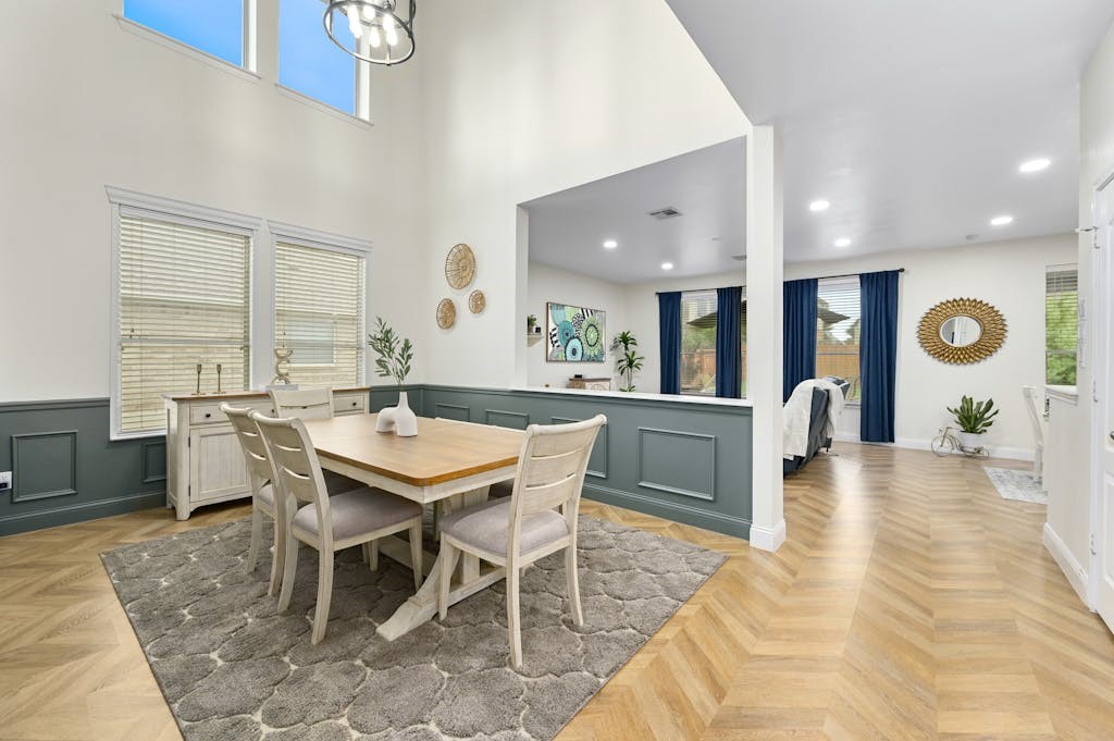 a dining hall with stainless steel appliances kitchen island a table and chairs in it