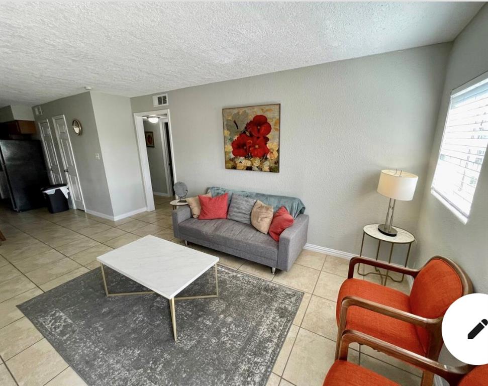 a living room with furniture a rug and a window