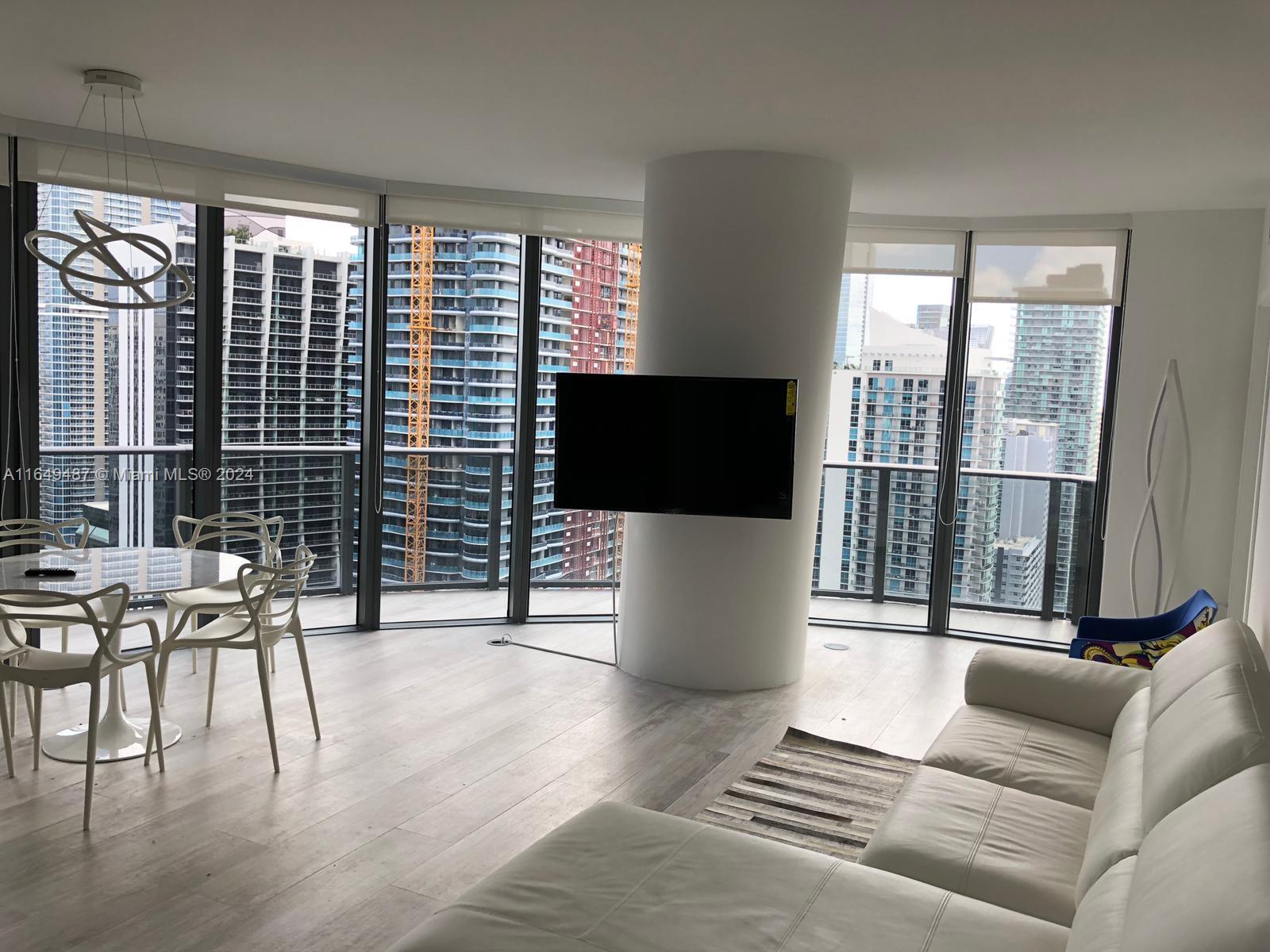 a living room with couches a coffee table and a flat screen tv