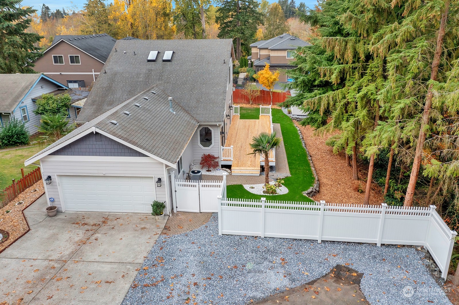 an aerial view of a house with a yard and large tree