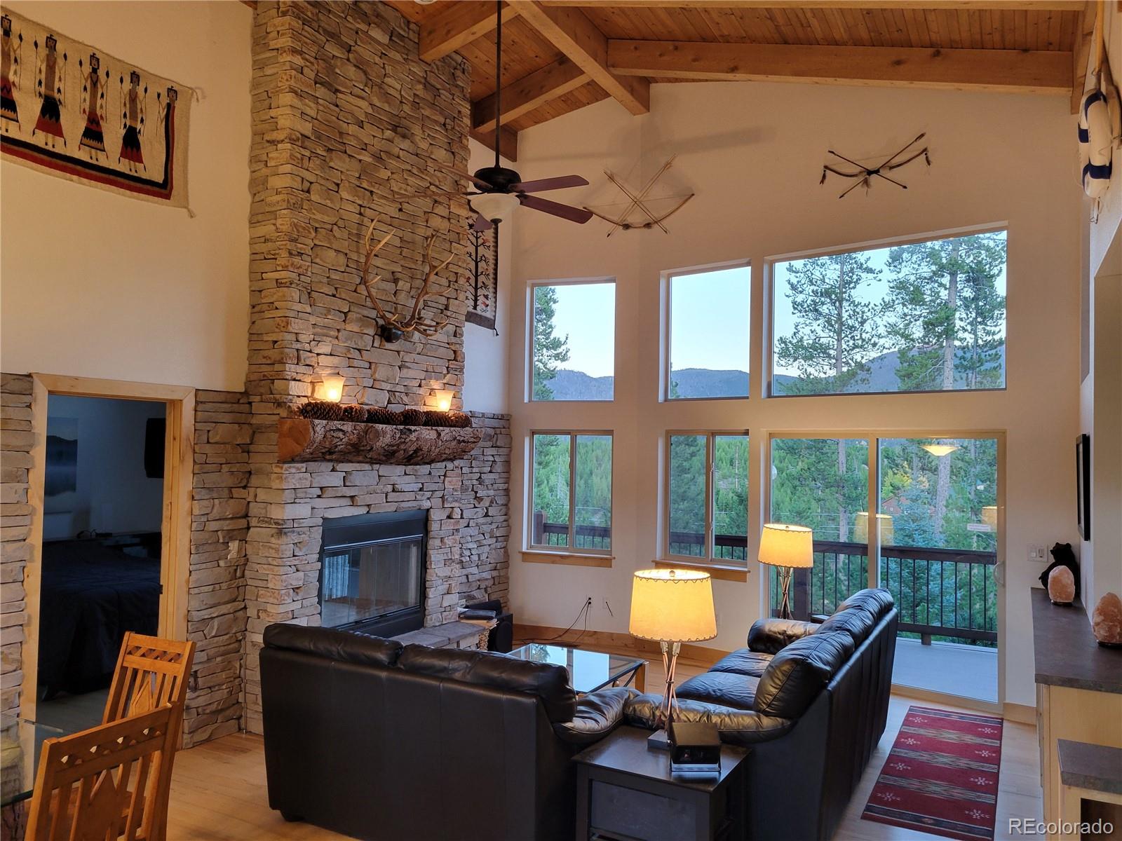 a living room with furniture a fireplace and a floor to ceiling window