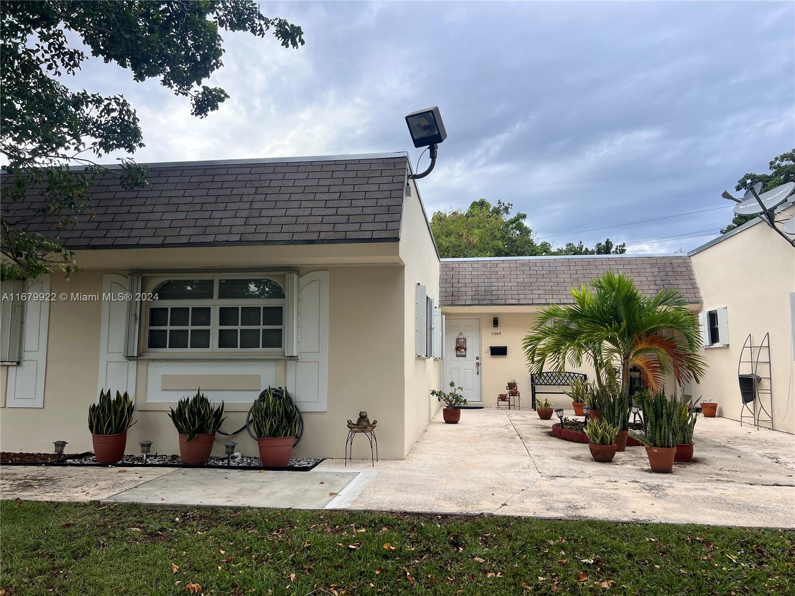 a view of a house with potted plants in front of door