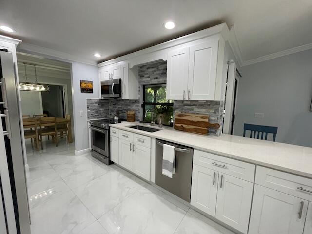 a kitchen with white cabinets and stainless steel appliances