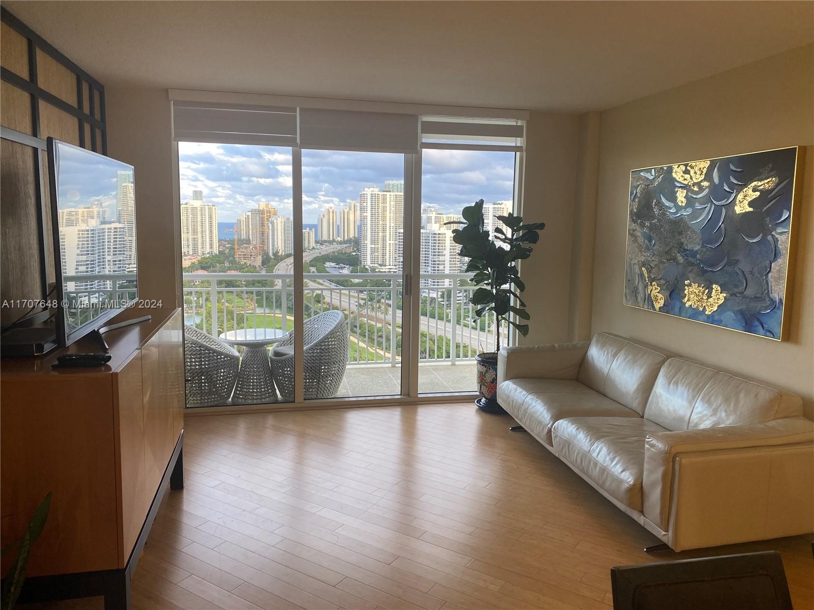 a living room with furniture large window and a flat screen tv