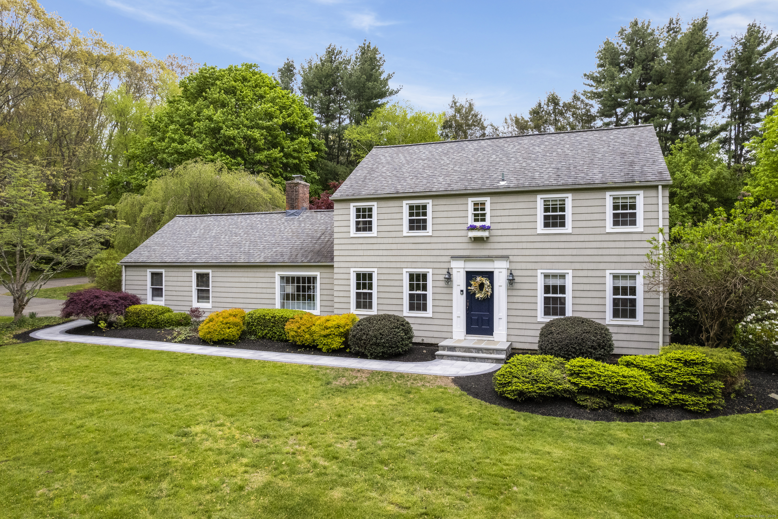 a view of a house with a yard and potted plants