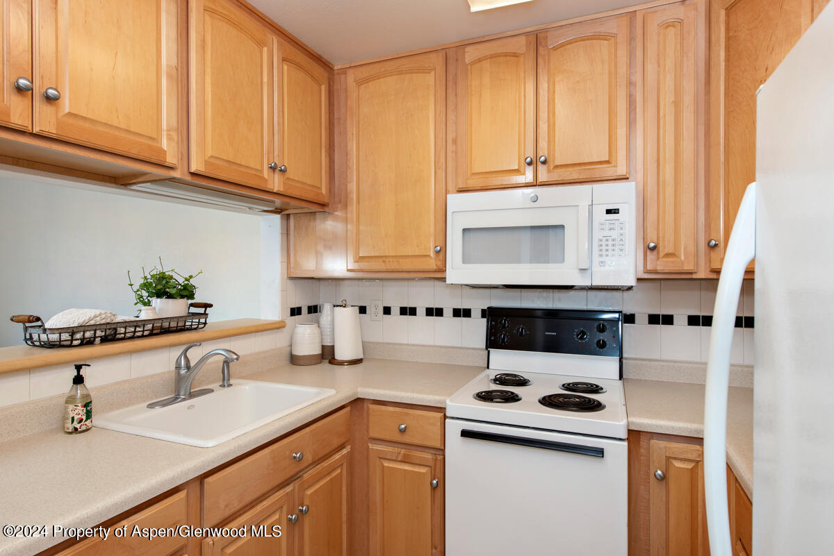 a kitchen with granite countertop a sink a stove and cabinets