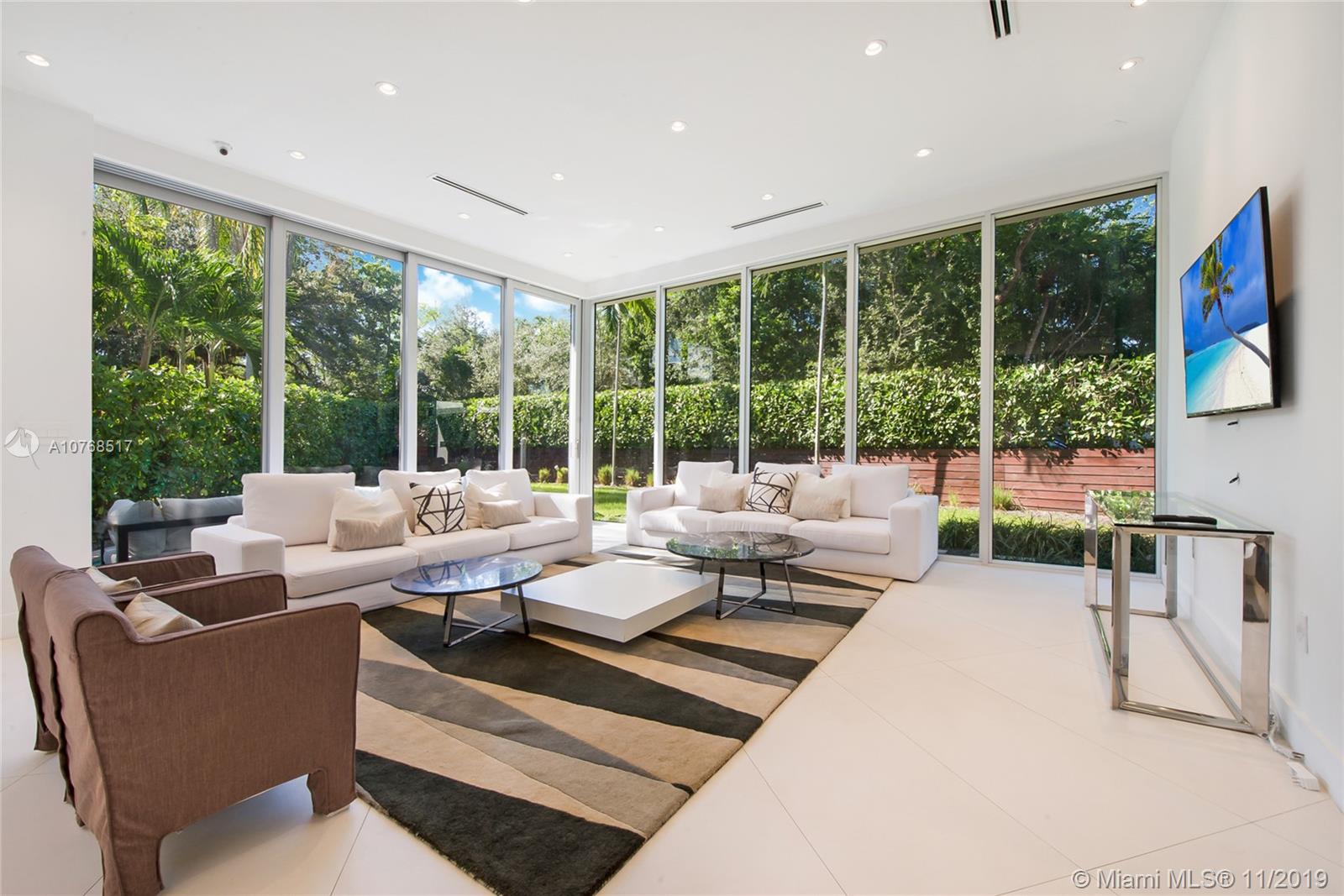 a living room with furniture large windows and a flat screen tv