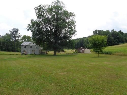 a front view of a house with a yard and trees