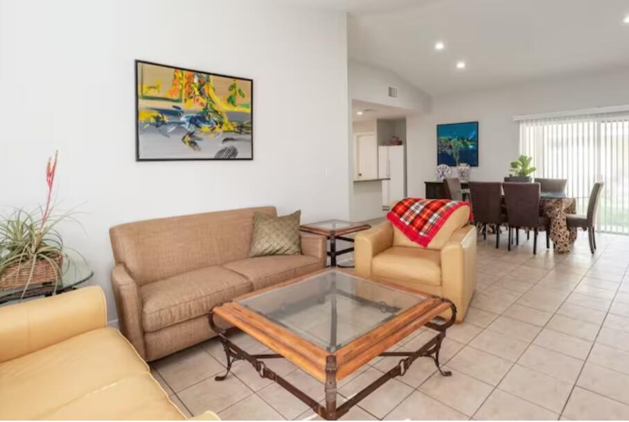 a living room with furniture a dining table and a flat screen tv